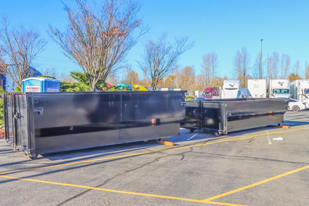 Professional dumpster rental service with roll-off container on residential driveway in Adrian